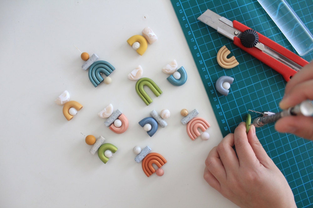 Jessica bores holes into her clay pieces so she can add earring hooks.