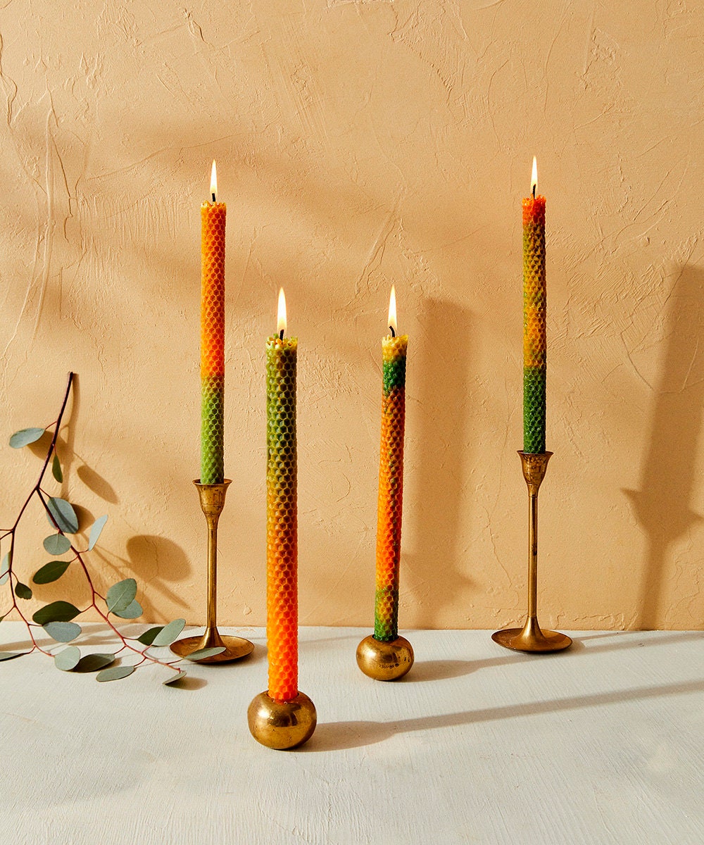 Orange and green taper candles with a honeycomb texture.