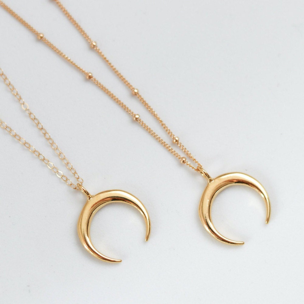 Two gold, crescent moon necklaces from EVREN.