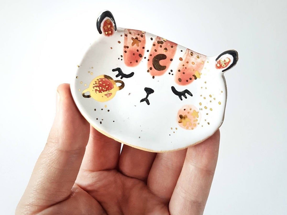 A ceramic, bear-shaped trinket dish painted with moons and planets from Mrs Biscuit Art