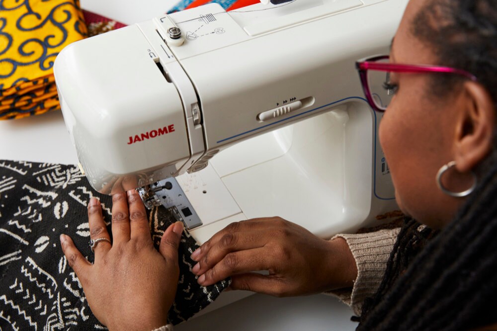 Natalie sews a mud cloth blanket on her sewing machine