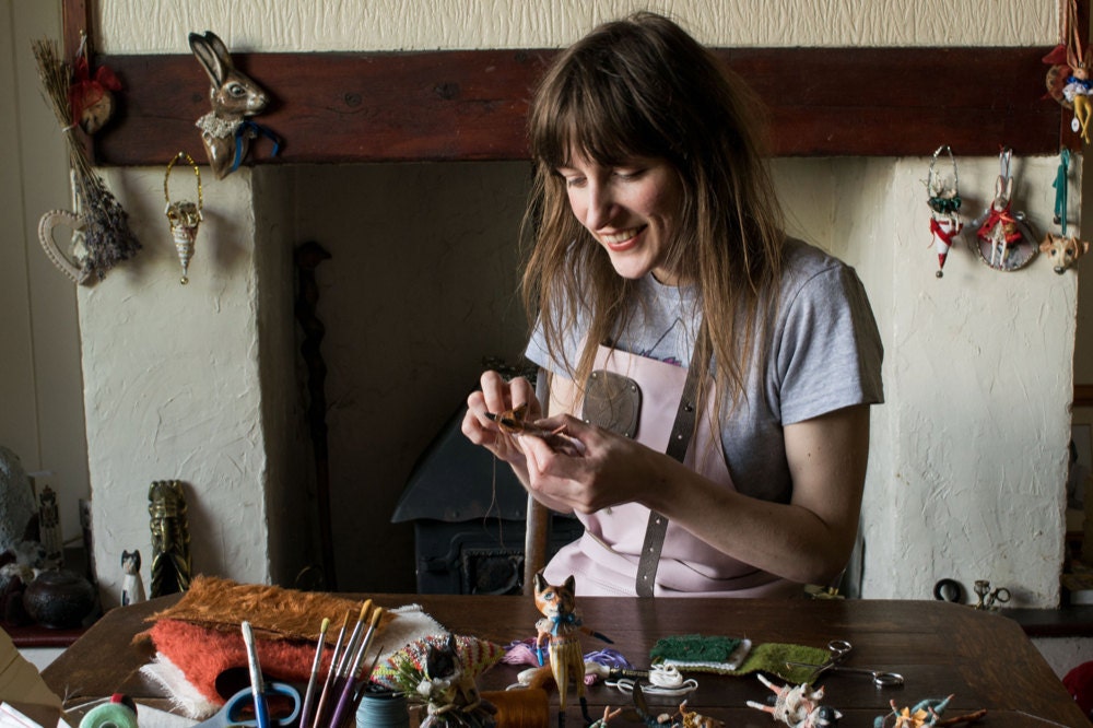 Kayleigh sews one of her magical creatures at her table