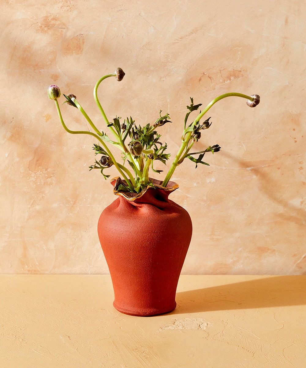 A ripple vase holds budding flowers.