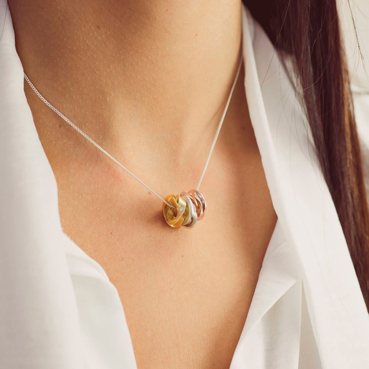 Personalized silver, yellow gold, and rose gold mobius necklace from Soremi Jewellery