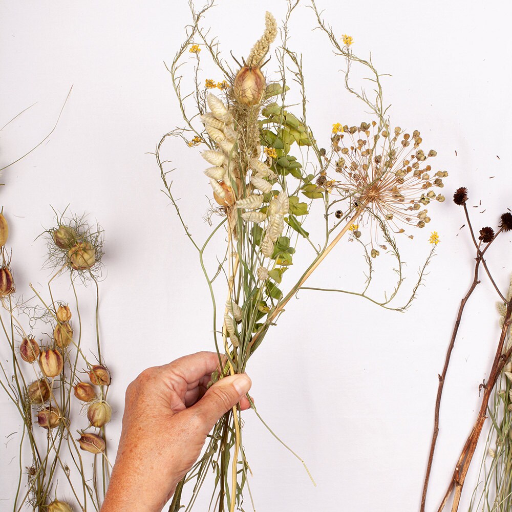 A person continues arranging their bouquet