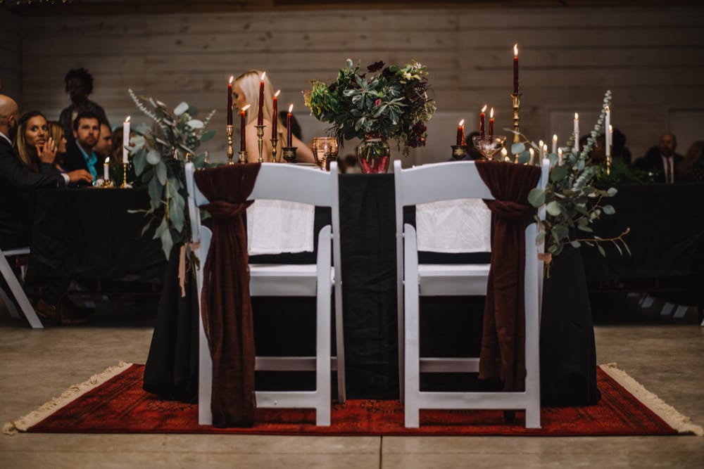 The couple's sweetheart table awaits them, adorned with gauzy fabric and bundles of eucalyptus