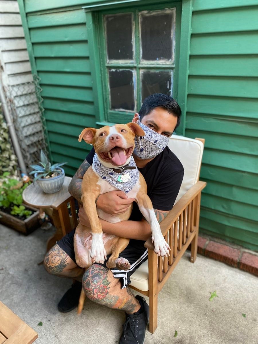 A man and his pitbull model a matching mask and bandana.