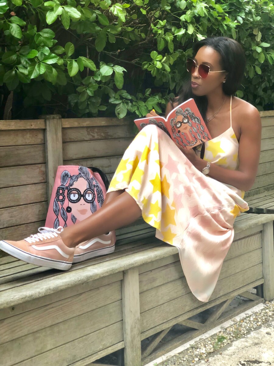 A model posing with Karina's "Book Smart" tote and notebook