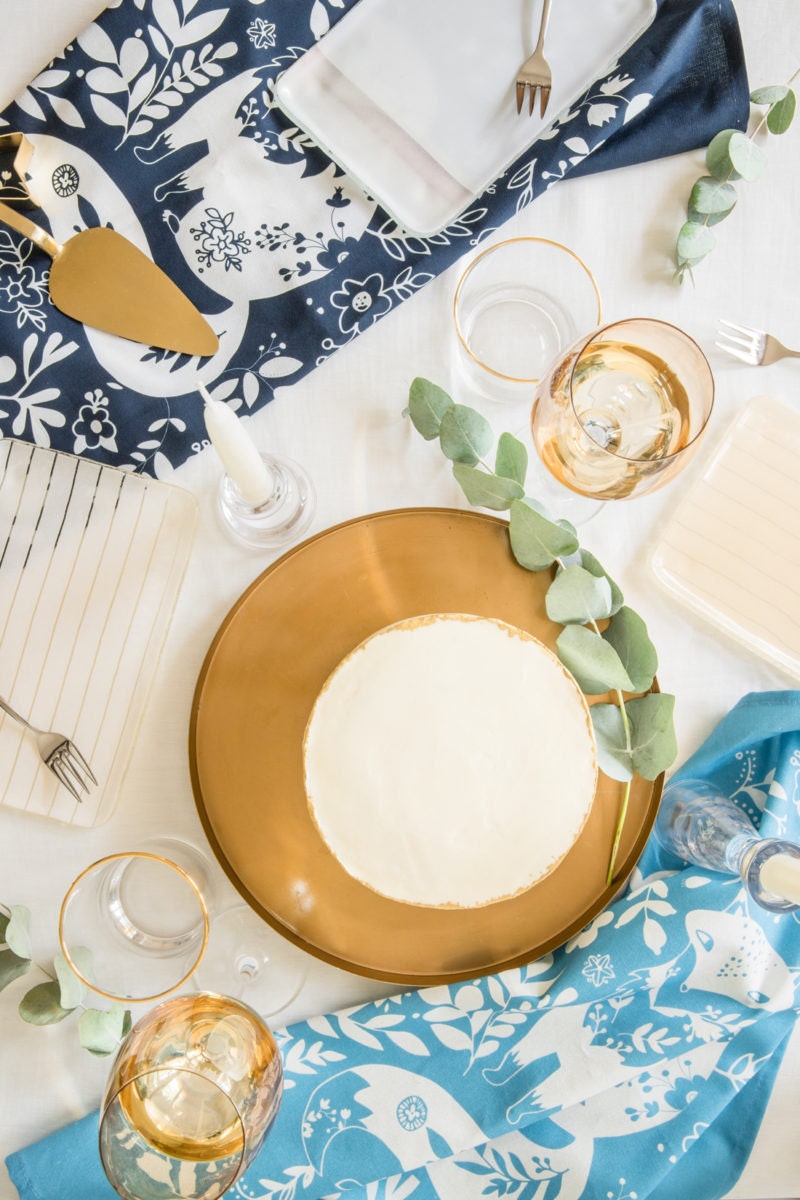 A styled tabletop featuring 2 woodland-themed tea towels from a set of 4