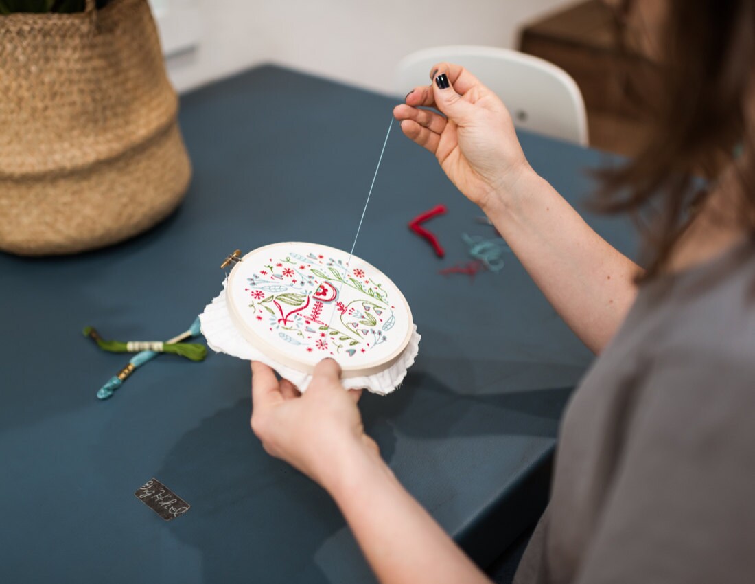 Liz stitches the details onto her Dala Horse design.