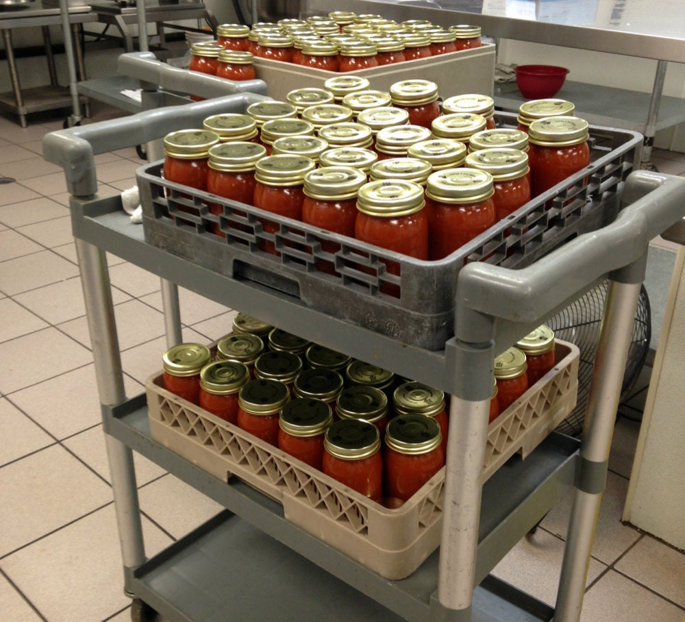 Stacks of jarred tomato sauce ready to be labeled