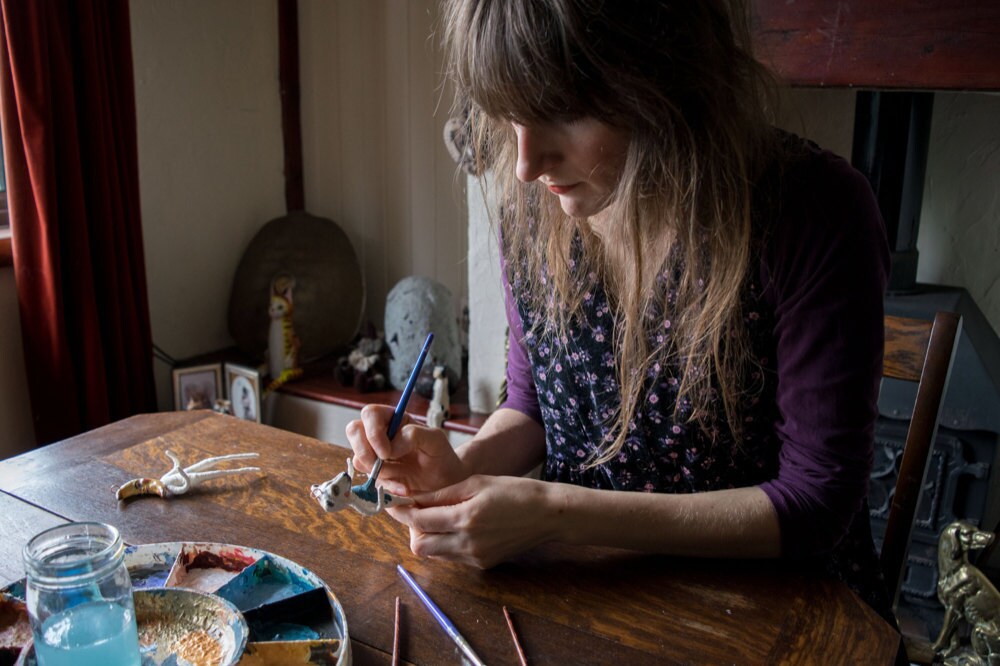 Kayleigh painting a bear ornament at her table