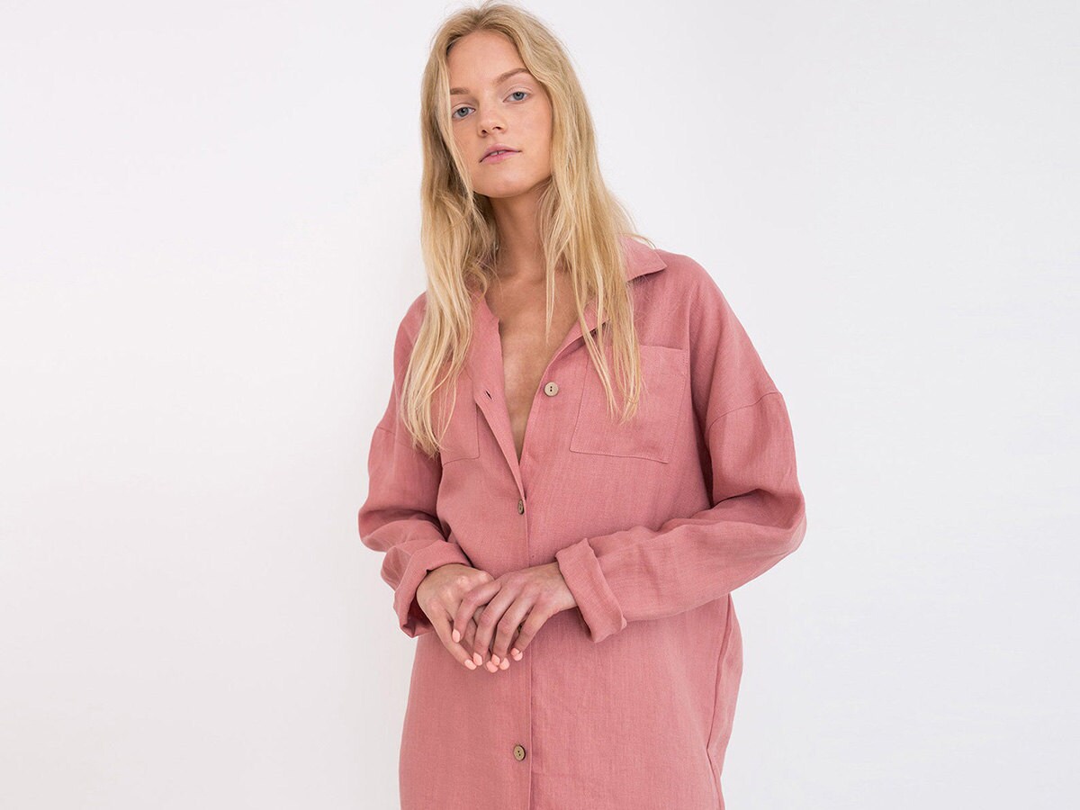 A salmon-colored button-down linen shirtdress on a model.