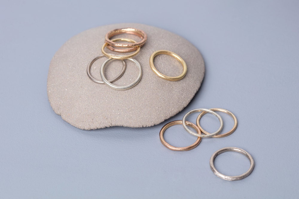 Assorted silver, gold, and rose gold rings on display