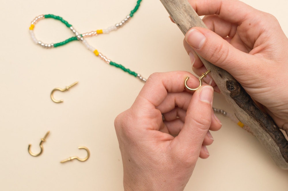 Screwing a cup hook into the bottom of the driftwood