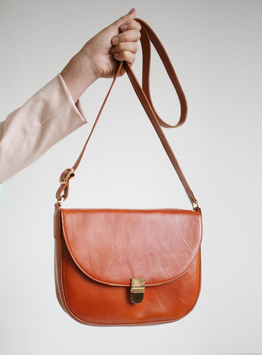 A crossbody buckle bag from Alex Bender in cognac