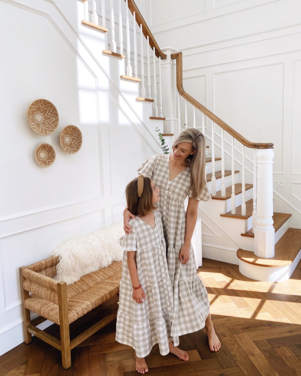 Kristine and her daughter, wearing matching linen dresses, embrace.