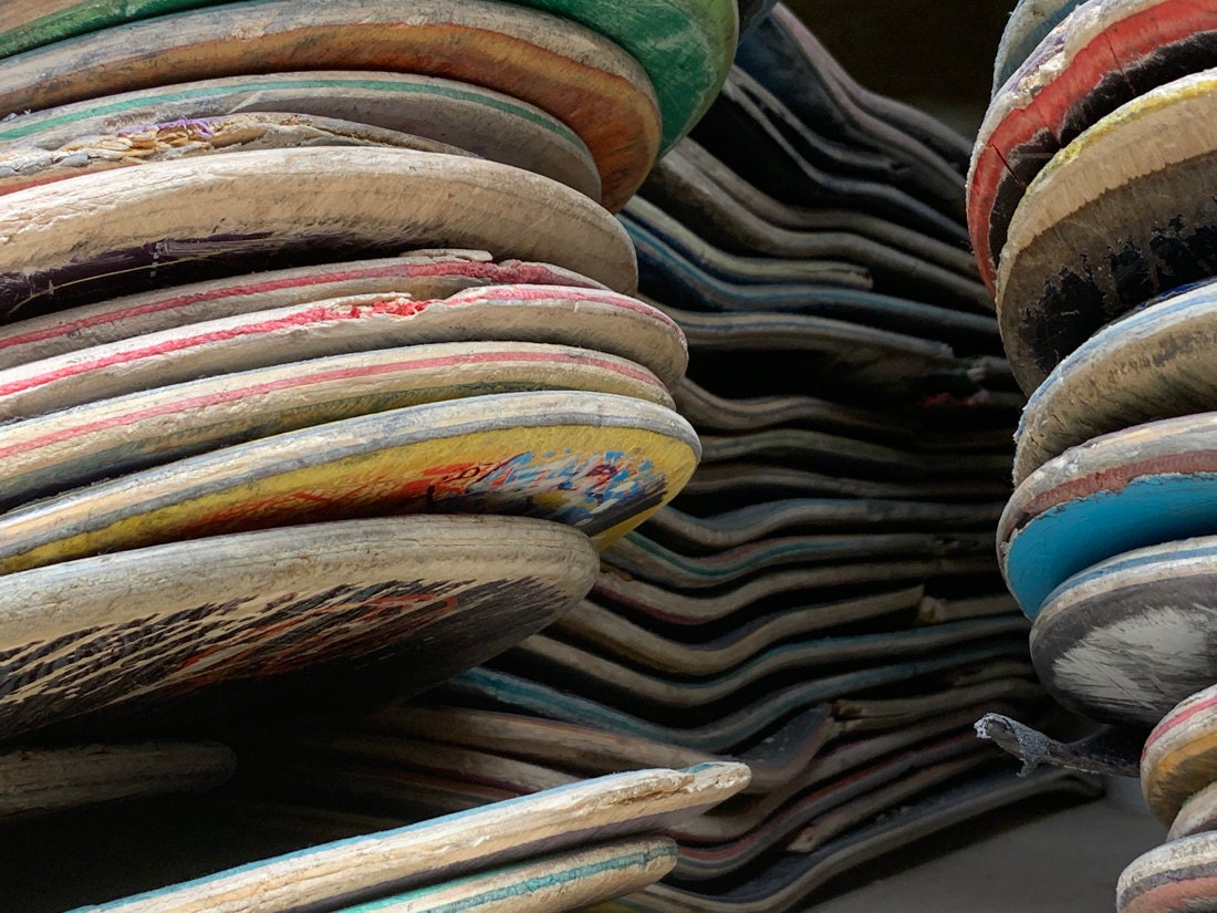 Stacks of curved skateboard decks ready to be repurposed