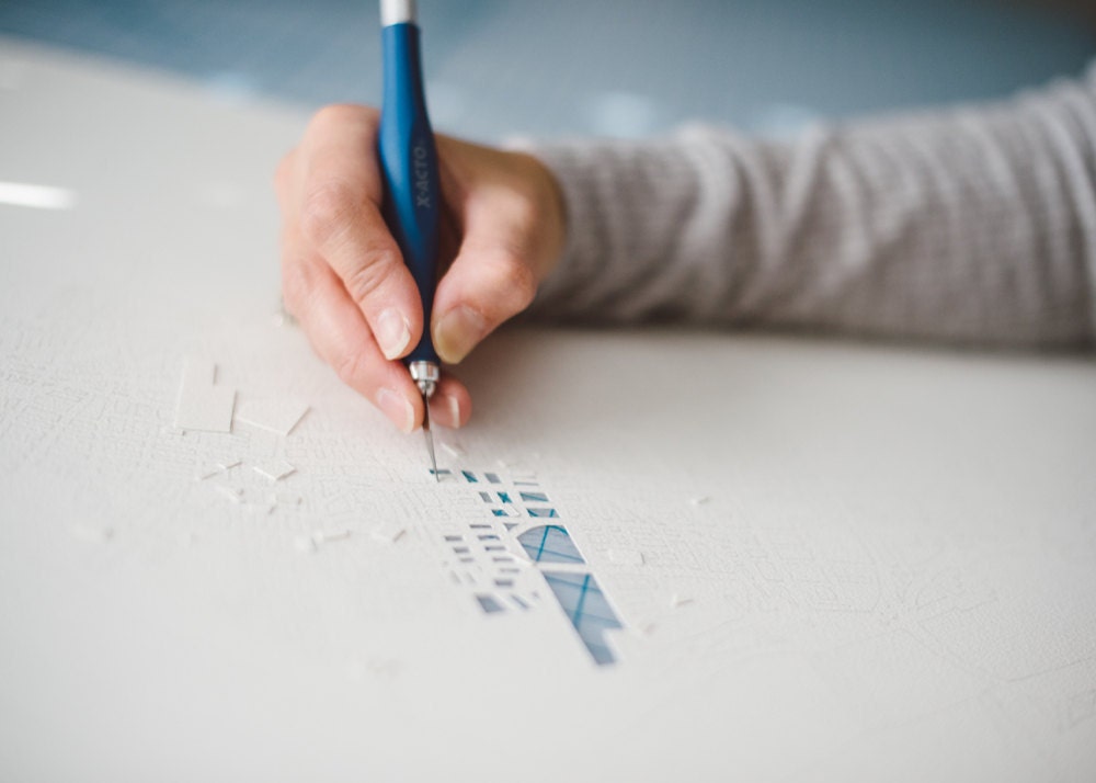 Close-up on Karen cutting a paper-cup map