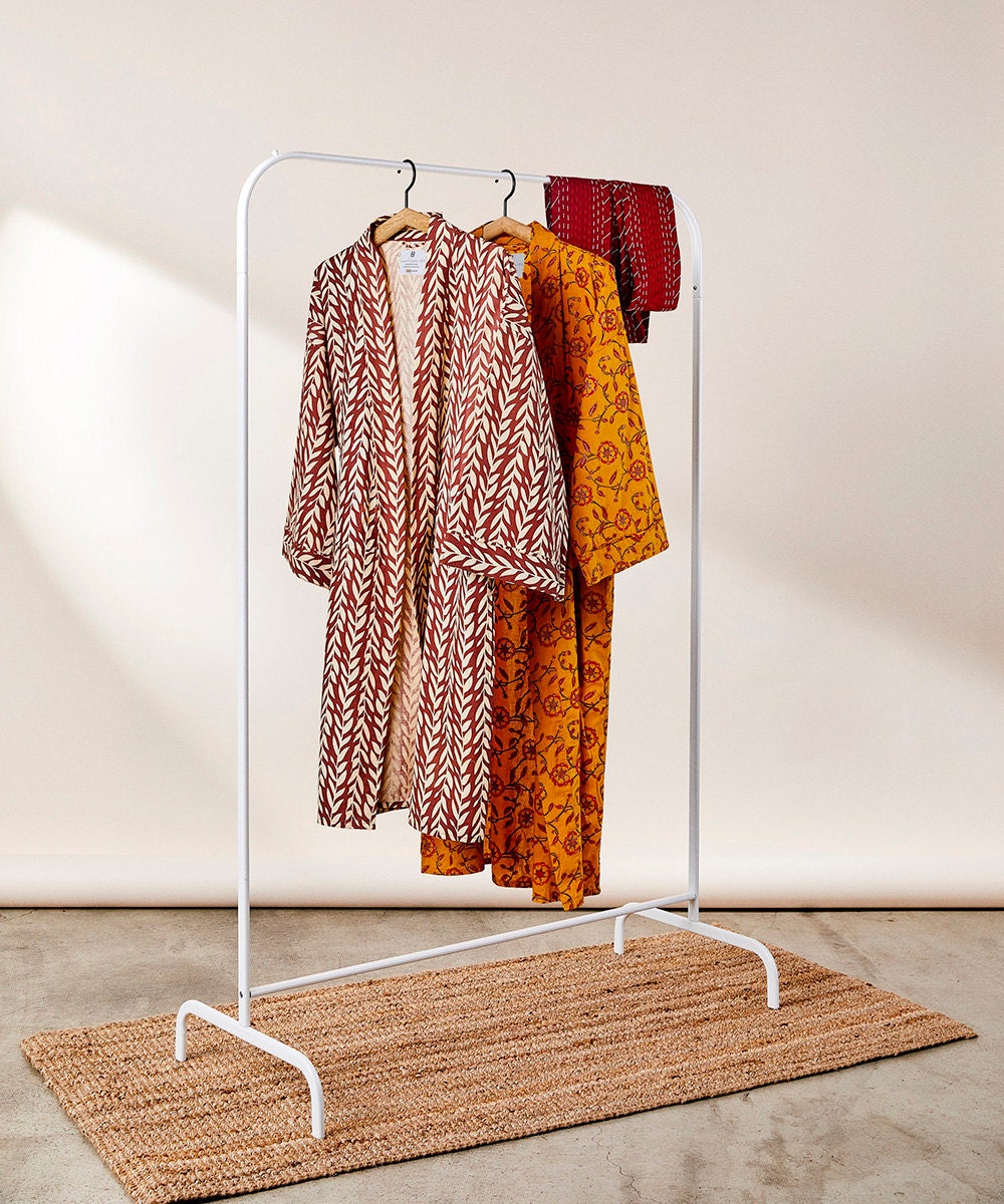 Colorful caftans on a clothing rack.