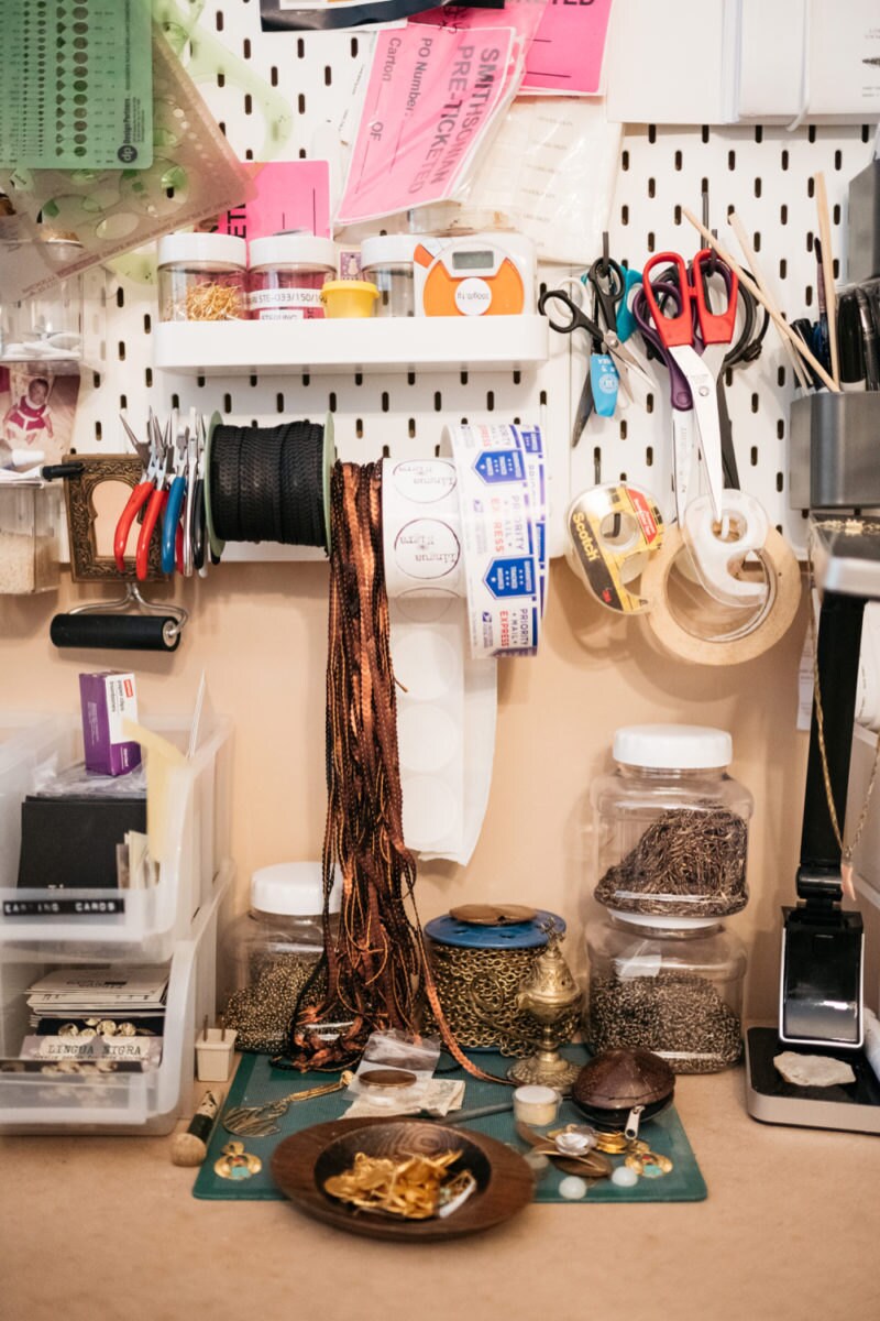 An organized section of Alicia's desk stocked with scissors, pliers, chains, fasteners, packaging stickers, and more