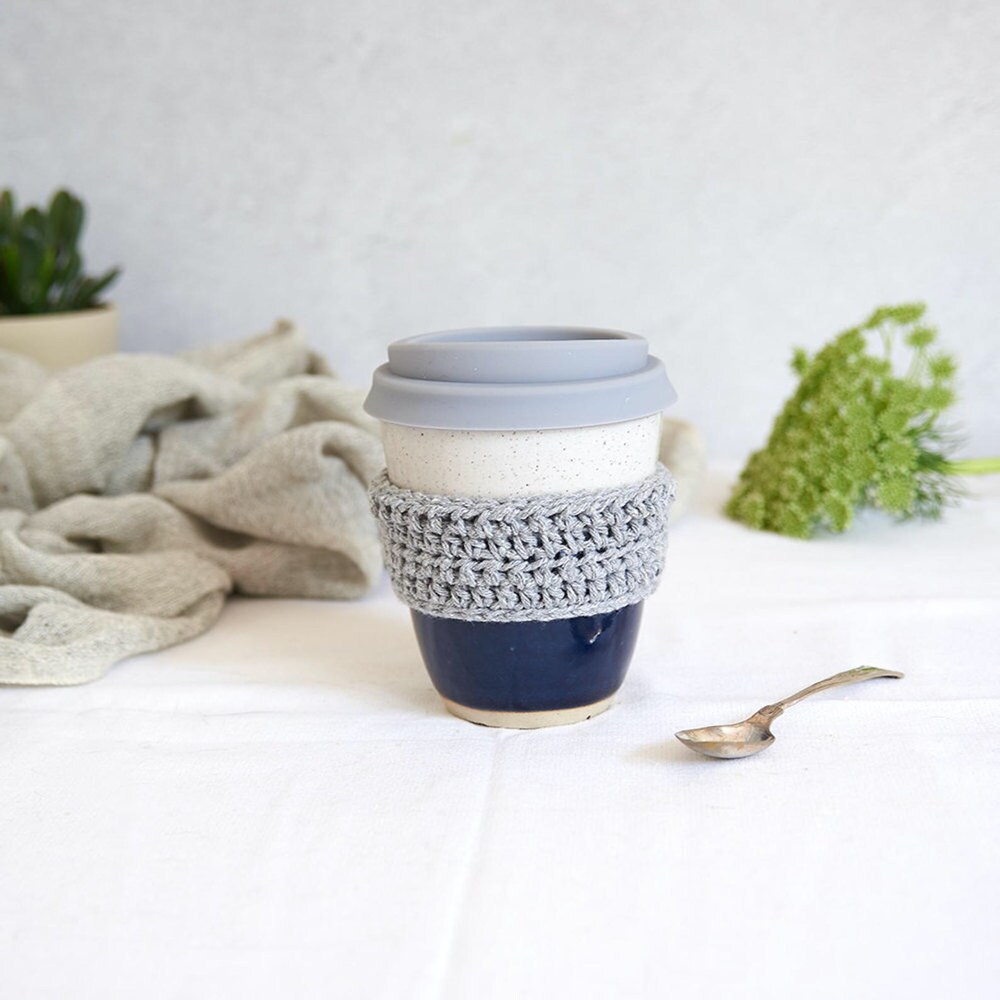 An eco-friendly ceramic travel mug with a crocheted grip from Libby Ballard Ceramics.