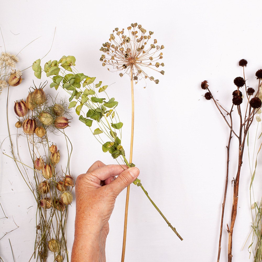 A person begins arranging their flower bouquet