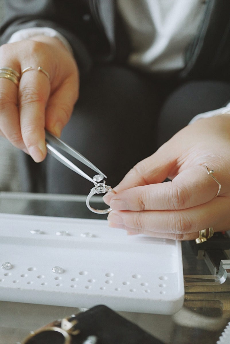 Katherine places a diamond into an engagement ring setting.