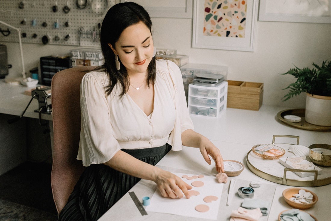 Elyse Tolles arranging clay shapes at her desk