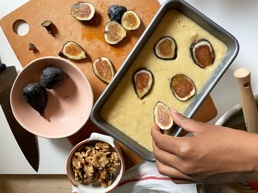 Aravis adding figs to the top of the batter.