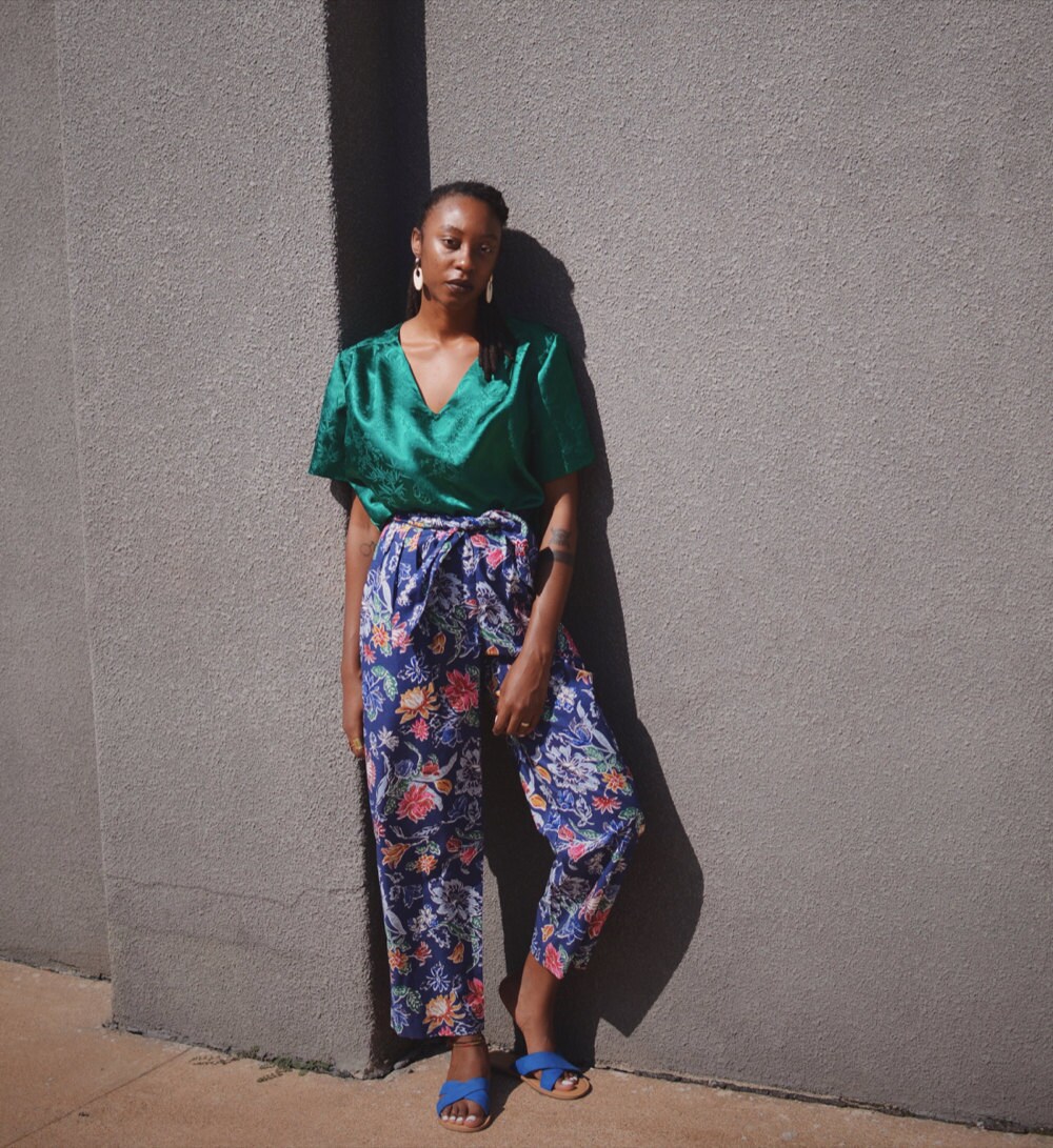 Rachelle models a silky green top and colorful floral trousers.