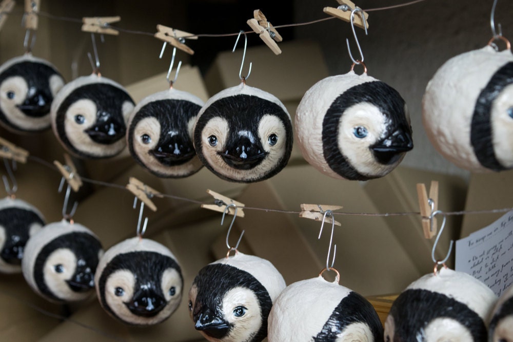 Painted baby penguin ornaments hanging up to dry
