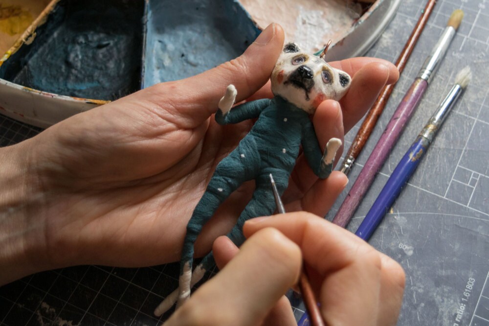 Kayleigh paints the cotton body of a bear ornament