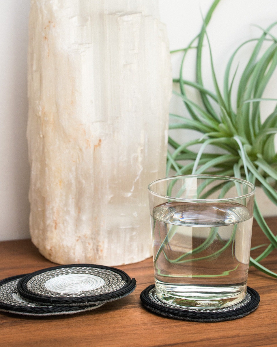 Finished coasters displayed with a glass of water