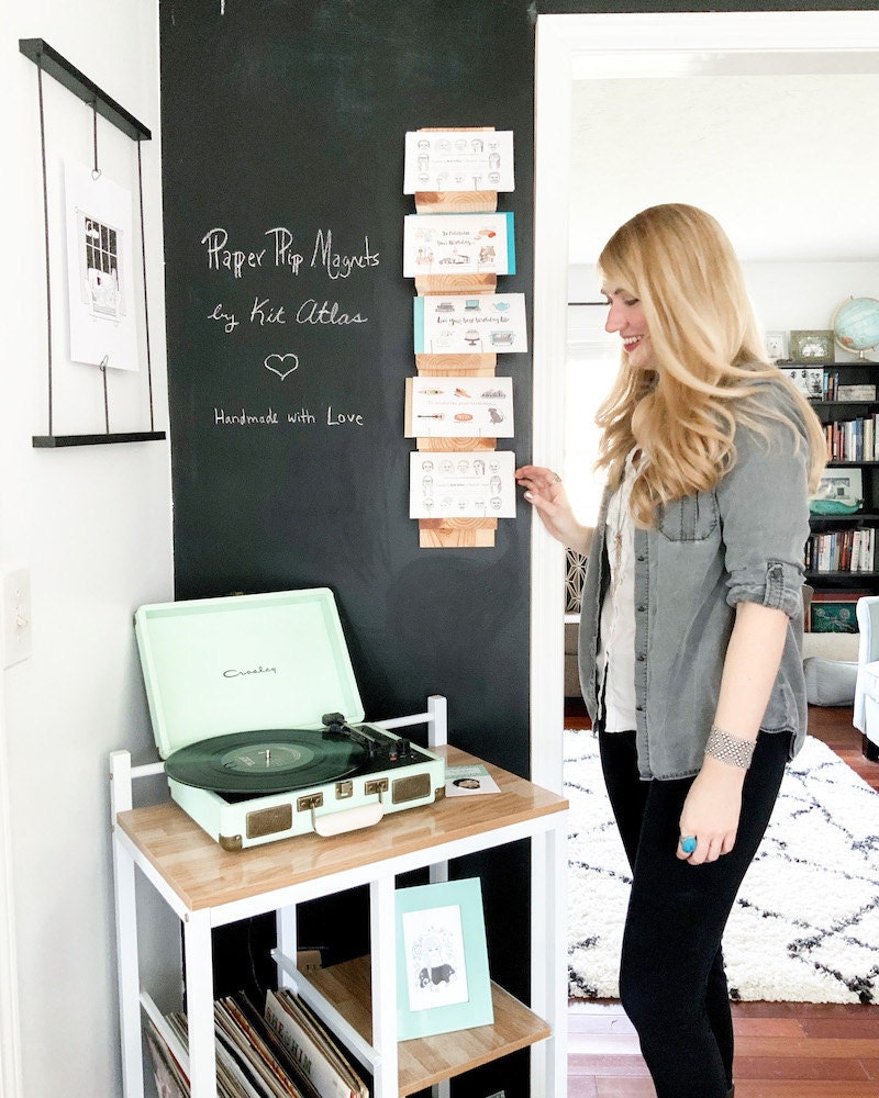 Brittney stands next to a chalkboard wall in her Kit Atlas home studio