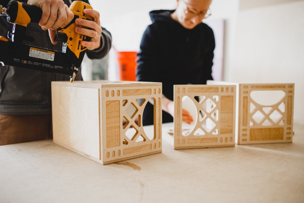 Andrew and Hanna work on assembling wooden milk crates.