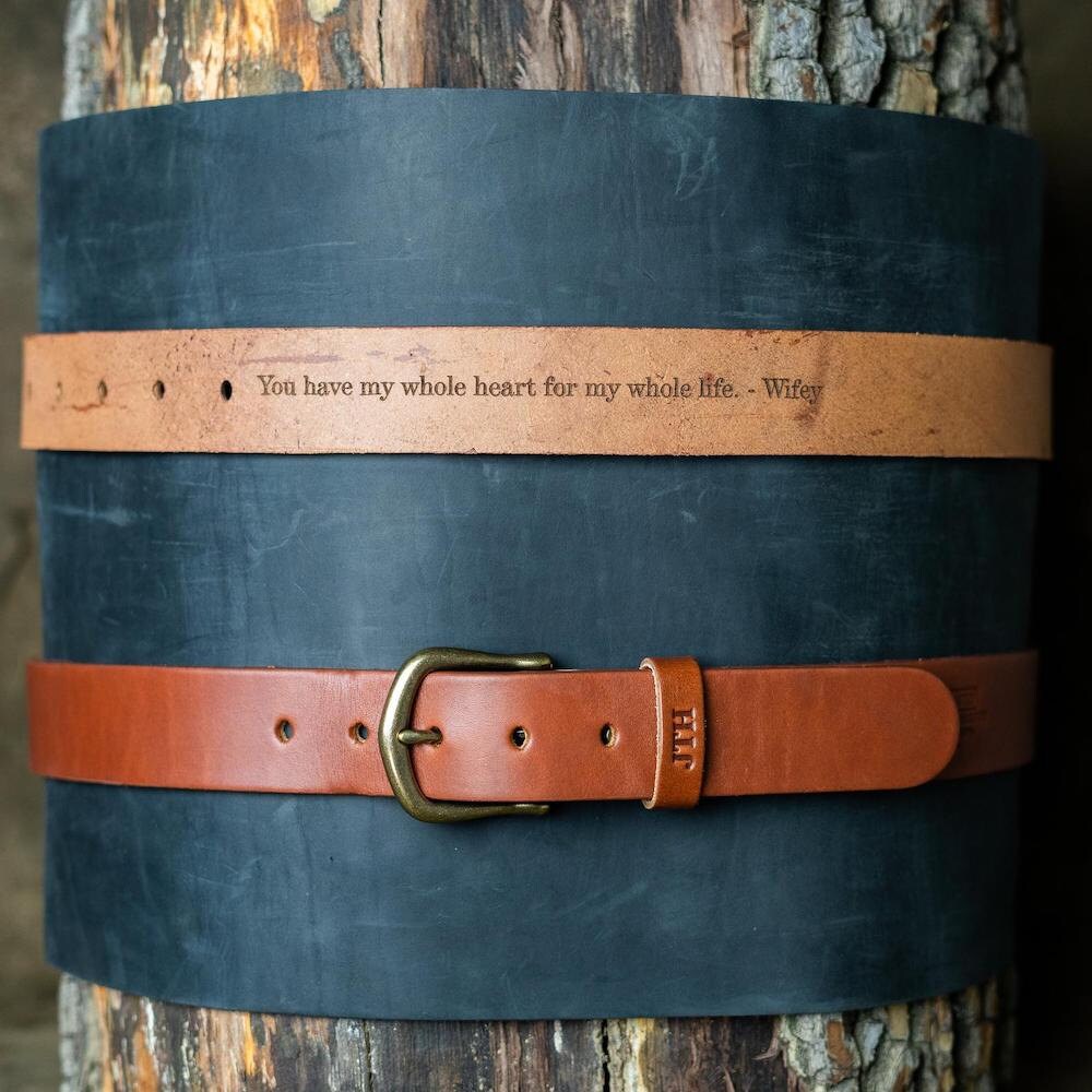 A personalized leather belt from Holtz Leather Co. inscribed with the words "You have my whole heart for my whole life. - Wifey" on the inside.