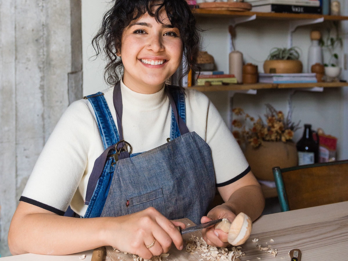 Melanie Abrantes carves a spoon in her sunny Oakland studio