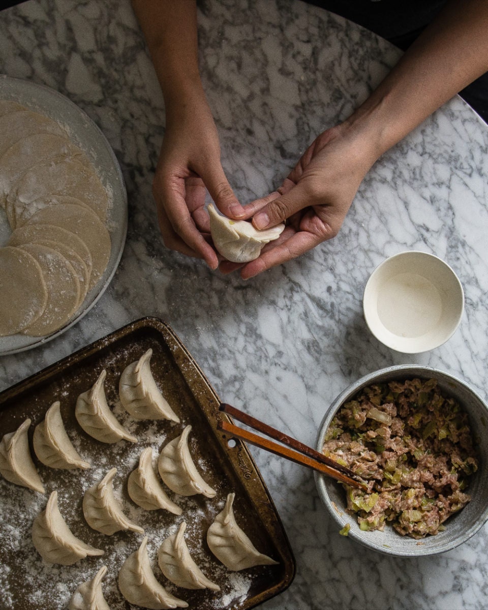 Sealing the dumpling edges and smoothing the shape Sealing the dumpling edges and smoothing the shape