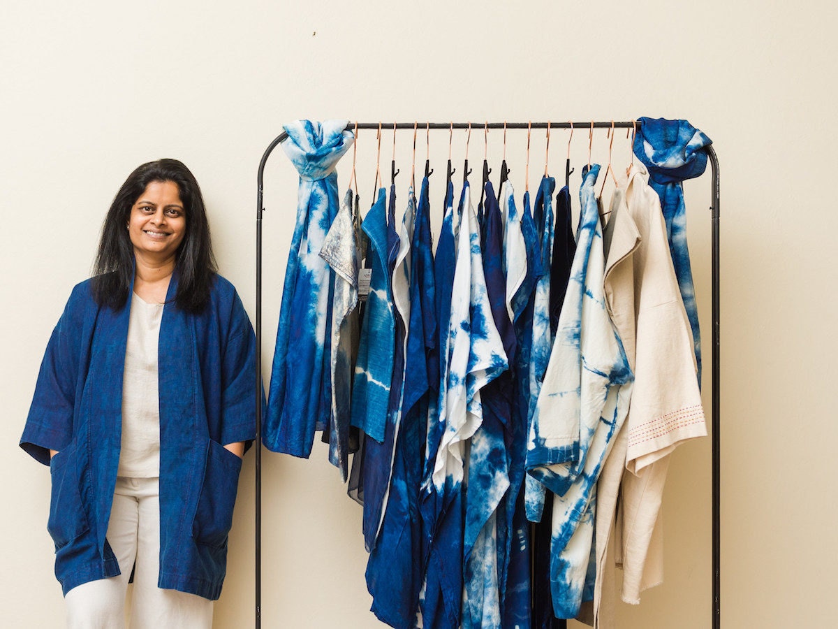 Adroit proprietor Rajni Kavula stands in front of a clothing rack filled with her hand-dyed pieces.