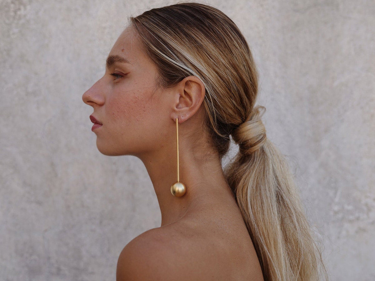 Spherical statement earrings on a model.