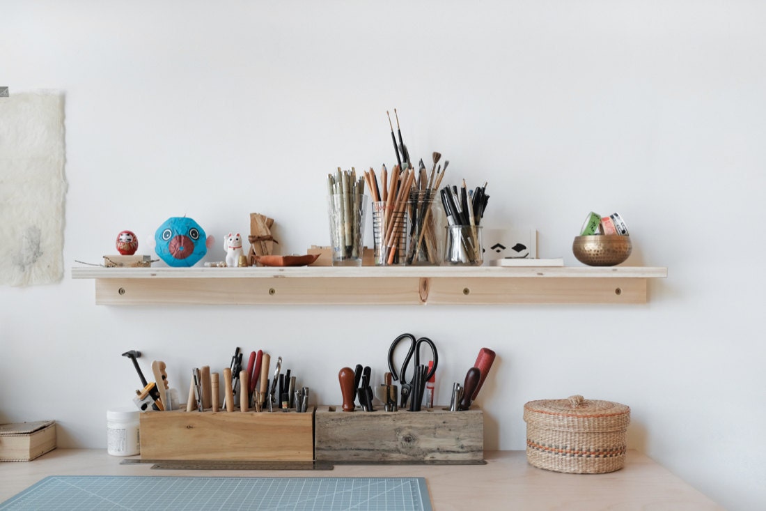 A closeup of Quynh's desk and shelf of tools and supplies