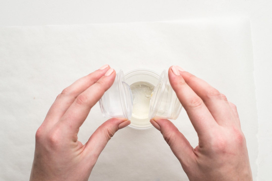 Mixing equal parts resin and hardener in a clear cup