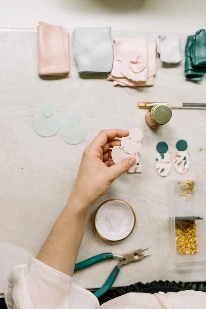 Elyse finishes adding fasteners to an earring