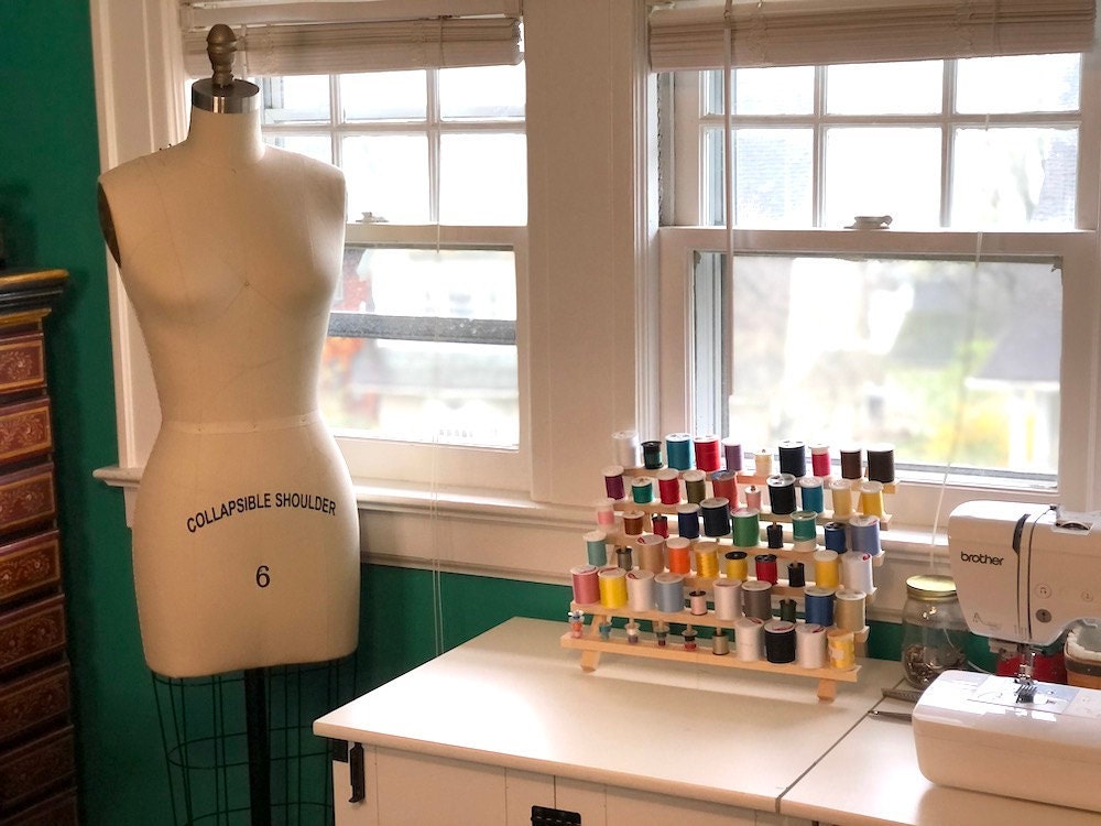 Halima's work area, stocked with colorful threads, a sewing machine, and a mannequin.