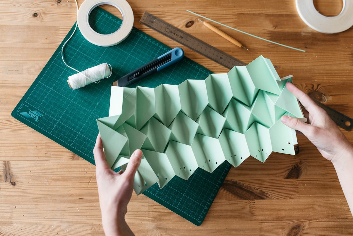 Close-up shot of the folded mint green paper lamp-in-progress