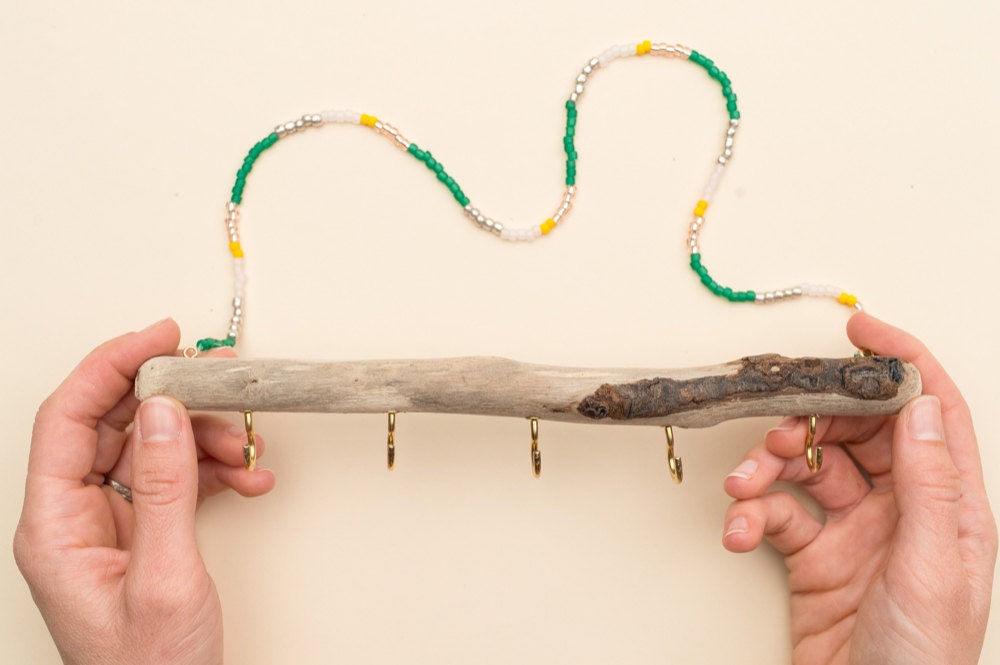 Two hands holding a finished driftwood jewelry organizer