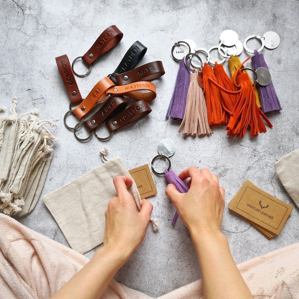 Pauline packages keychains on the floor of her studio