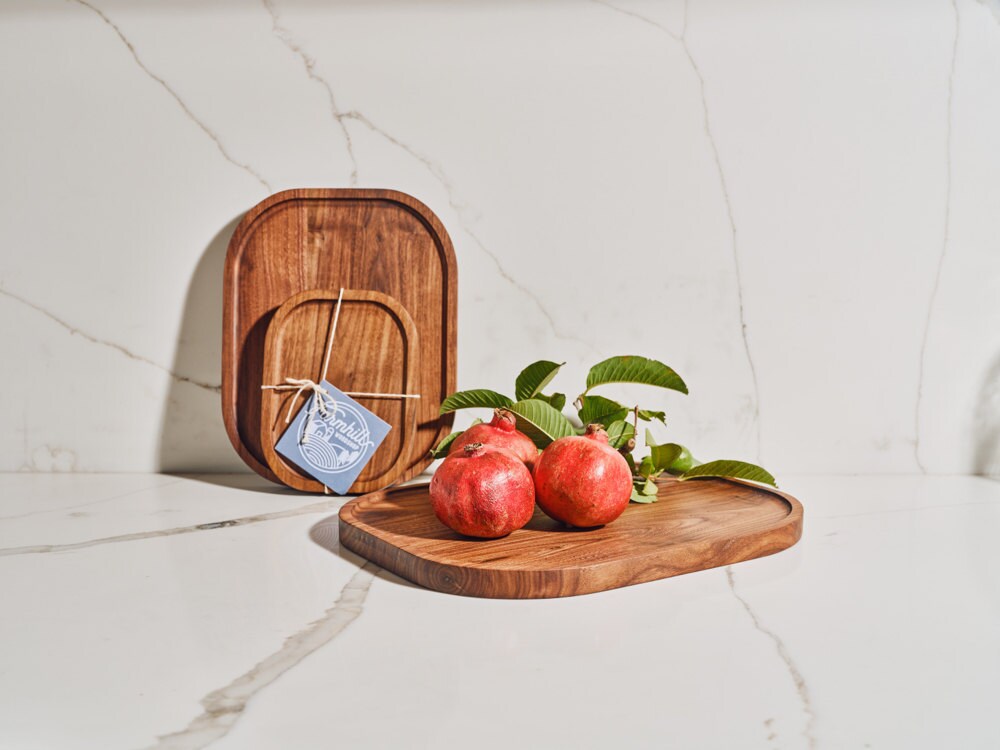 A styled shot of walnut serving trays from the Tan France x Etsy collection
