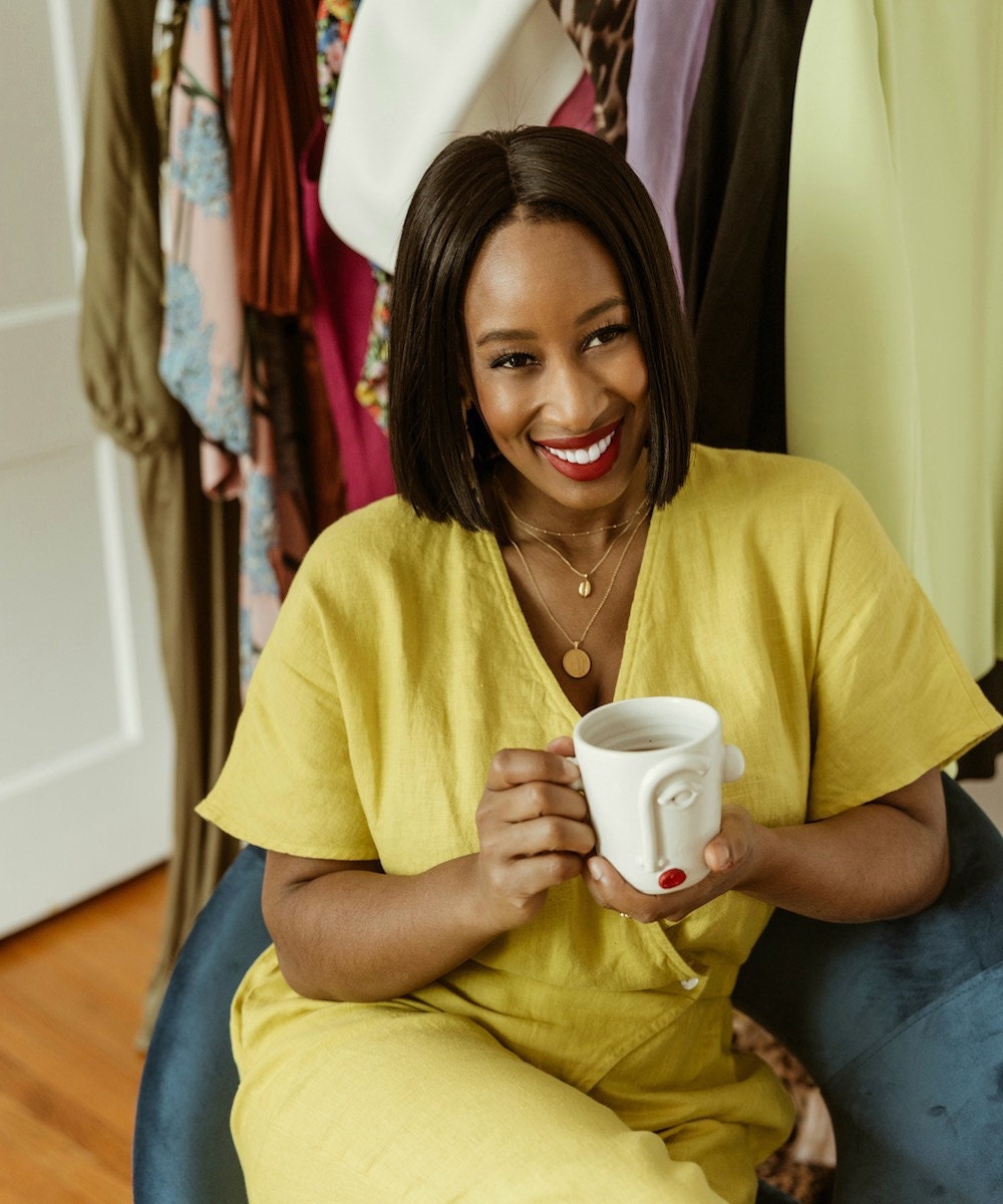 Shay sitting at home holding her face cup